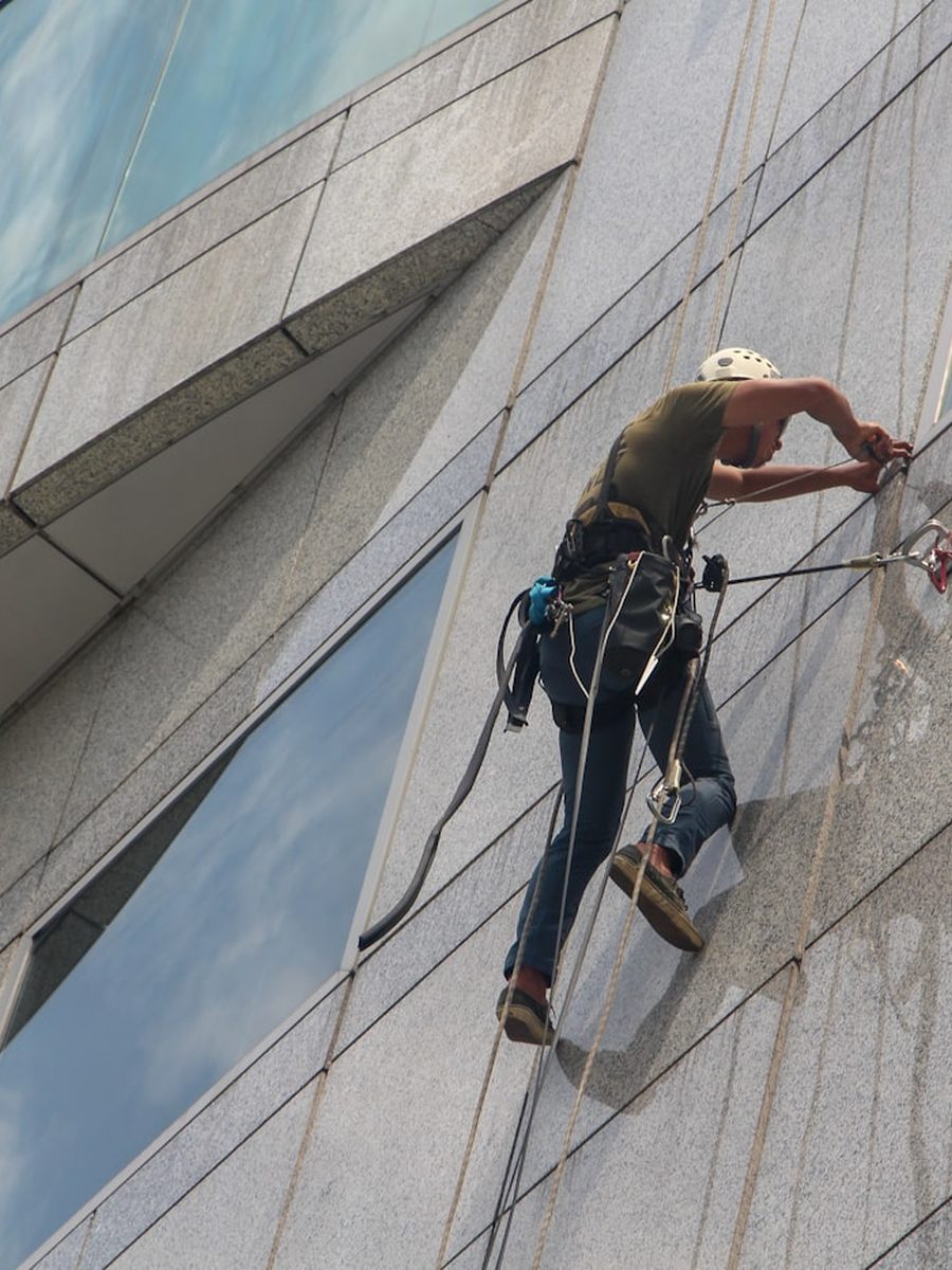 Fassadenreiniger arbeitet mit Seilzugang an einer Hochhausfassade
